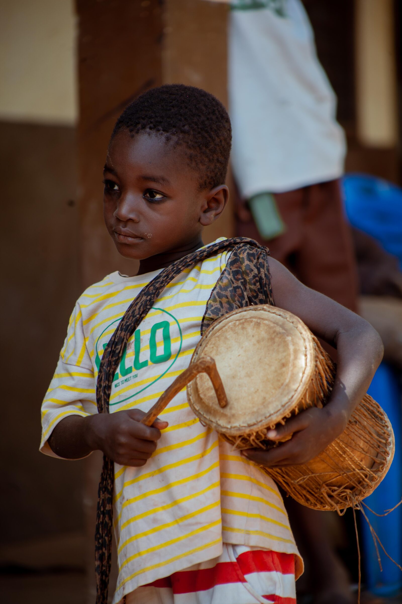 Boy in Ghana holding a drum and stick